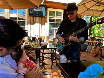 Rolando Morales serenading attentive baby at Maria, Maria in Walnut Creek